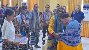 Masyarakat Desa Silu melakukan tutur adat, menyerahkan sirih pinang dan mengenakan kain tenun ikat kepada Bupati Kupang Korinus Masneno sebagai simbol persaudaraan dan permohonan maaf atas terjadinya insiden penghadangan oleh oknum warga beberapa waktu lalu. FOTO HO- Prokopim Setda Kabupaten Kupang.