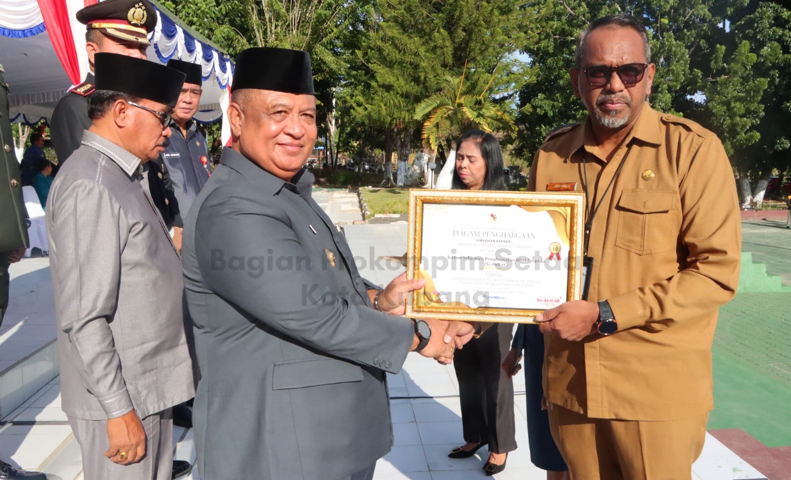 ser 2 Penjabat Wali Kota Kupang Fahrensy Priestley Funay menyerahan dua penghargaan inovasi dalam Kompetisi inovasi pelayanan publik (KOIN-YANLIK) tahun 2023 yang diselenggarakan Pemerintah Provinsi Nusa Tenggara Timur, usai Upacara Peringatan Hari Lahir Pancasila Tingkat Kota Kupang Tahun 2024, bertempat di Lapangan Upacara Kantor Wali Kota Kupang, Sabtu (1/6).