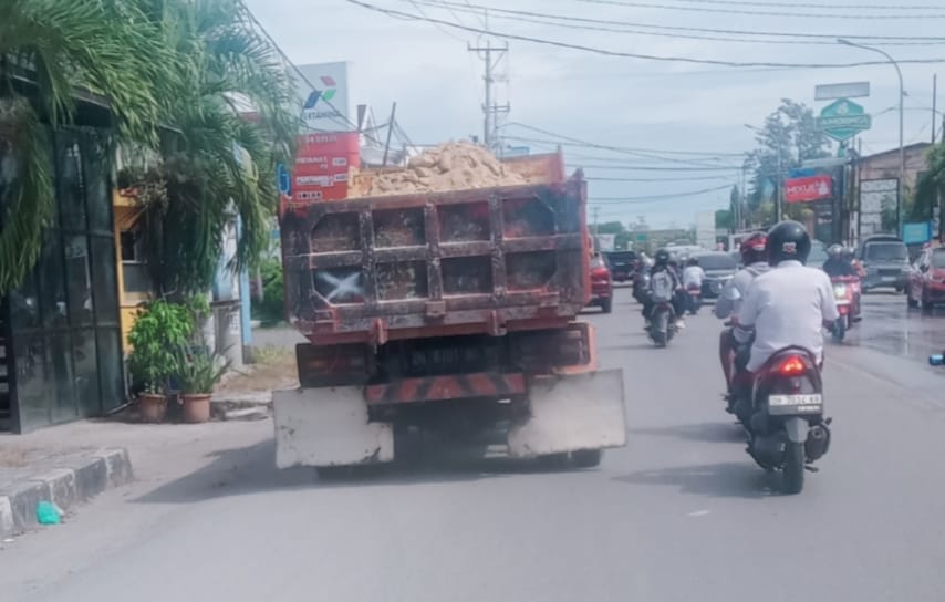 truk 1 FOTO/MEDIASINTT.COM/BEN- Satu unit truk pengangkut material galian C melintas di ruas jalan W.J.Lalamentik, Senin, tanpa penutup terpal menyebabkan debu beterbangan karena tiupan angin.