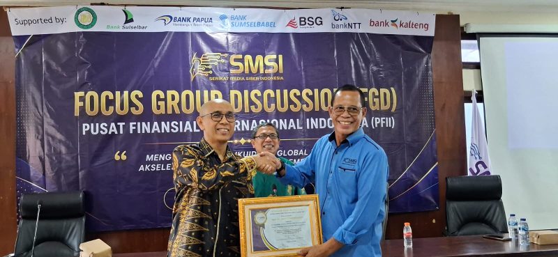 Ketua SMSI Provinsi Bali Emanuel Dewata Oja (kanan) menyerahkan cendera mata kepada narasumber dalam Focus Group Discussion (FGD) bertajuk "Membedah Masa Depan Kedaulatan Finansial: Peluang dan Tantangan Pusat Finansial Internasional Indonesia (PFII)" yang diselenggarakan di Bali, Jumat (10/7).